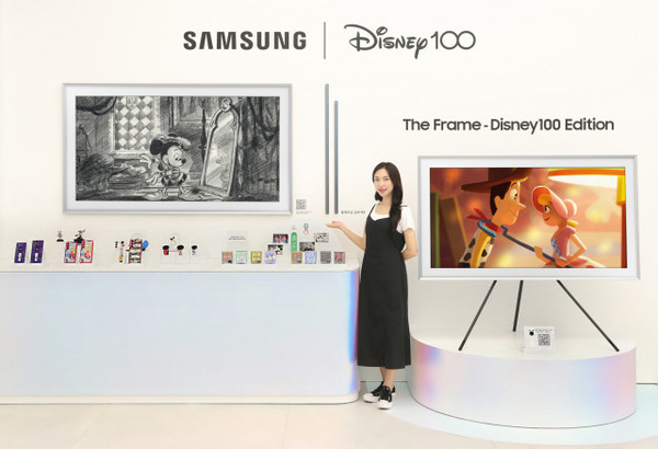 삼성전자 모델이 삼성 강남 ‘디즈니 콜라보 전시’에서 ‘더 프레임 디즈니 100주년 에디션’을 소개하고 있다.